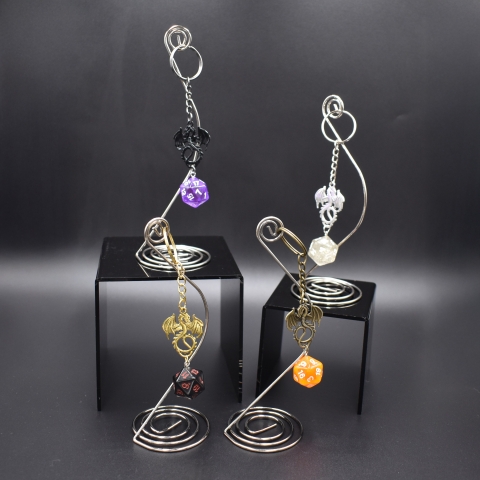 Four keychains consisting of metal dragon charms with 20-sided dice.