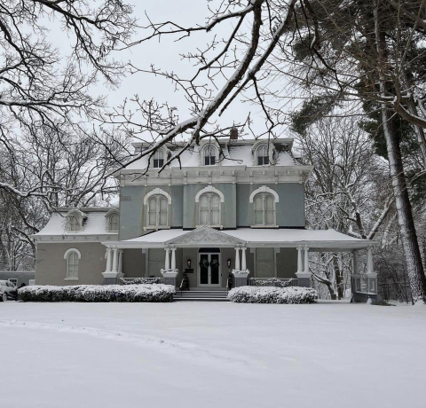 photo of Pettengill-Morron House in Peoria, Illinois big light blue house in the winter