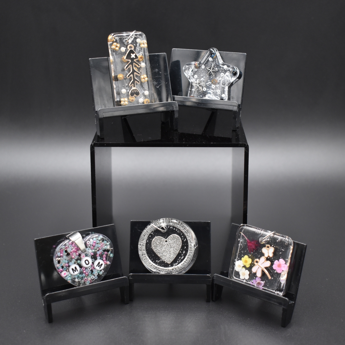 Resin pendants with beads and charms embedded inside.