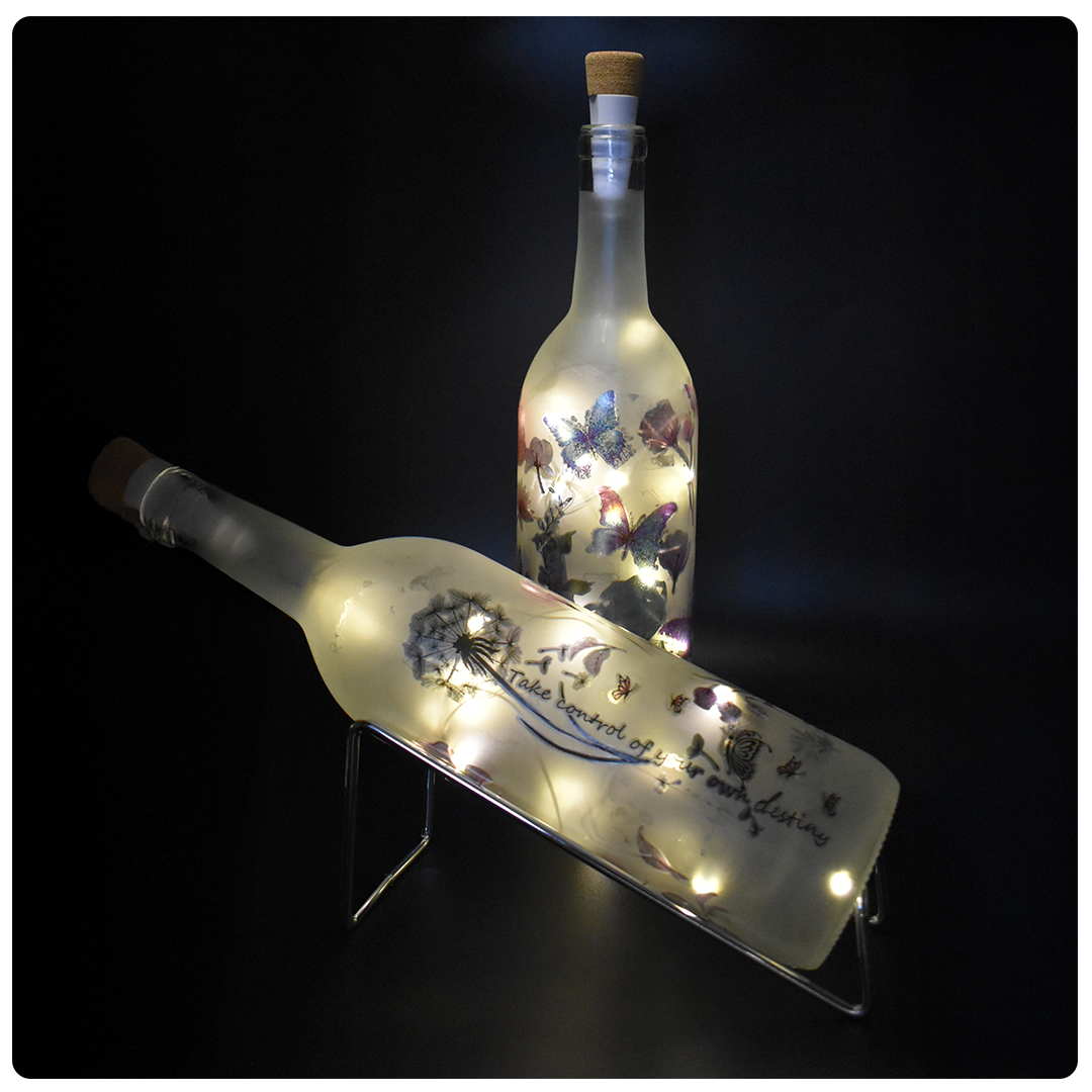 two wine bottles with glowing strings of lights inside