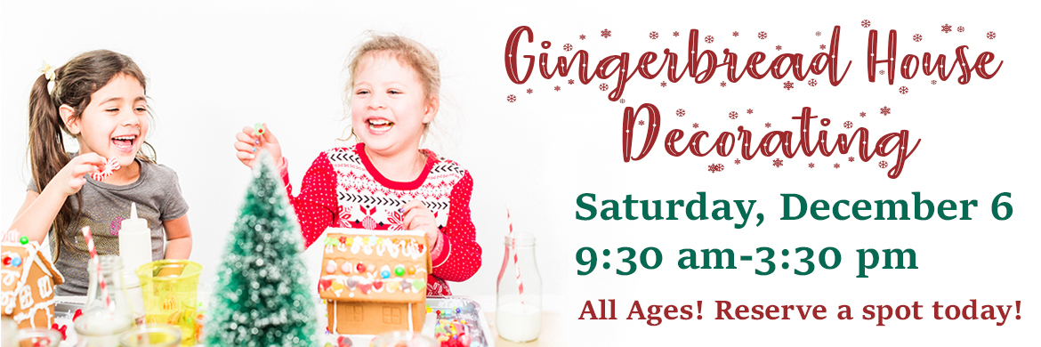 photo of two young girls decorating a gingerbread house